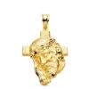 Colgante de oro amarillo de 18 quilates con el rostro de Cristo en relieve sobre una cruz latina, tamaño 35x25 mm sobre fondo blanco.